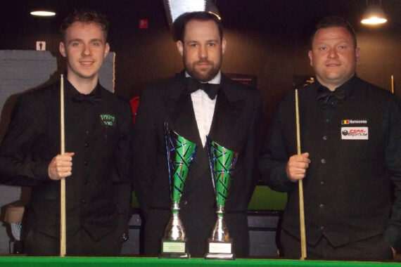 Sybren Sokolowski and Kevin Hanssens stand either side of the referee and behind the trophies which are on the table.