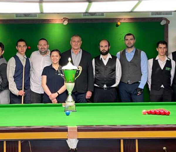 Players in the 2023 Bulgarian Snooker Championship pose for a photo by the table with the trophy on it.