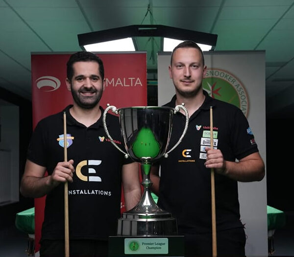 Aaron Busuttil and Brian Cini pose with cues in front of the big Maltese Snooker Championship trophy.