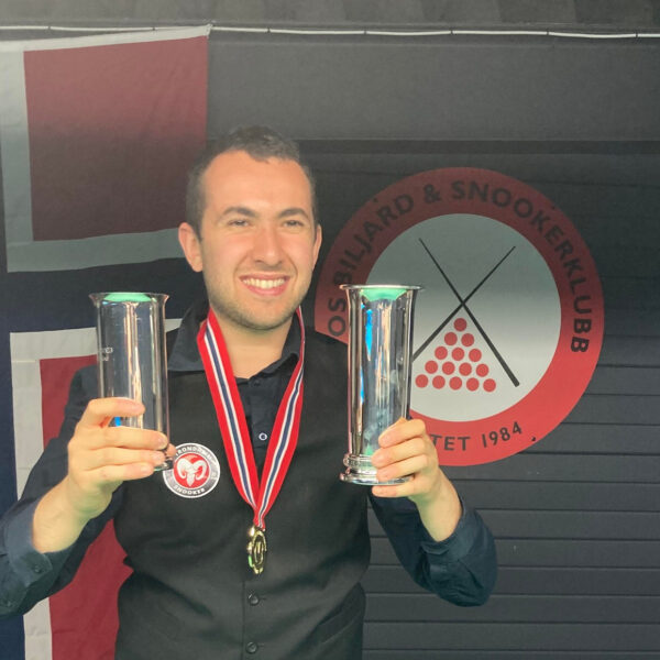 Nassim Sekat poses with his trophies and medal around his neck.