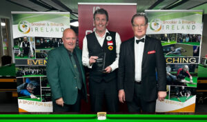 Peter Gilchrist holds the trophy by the table, either side of officials.