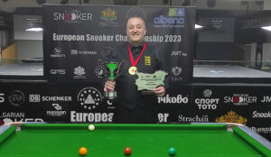 Wayne Brown holds his trophies and wears his medal.